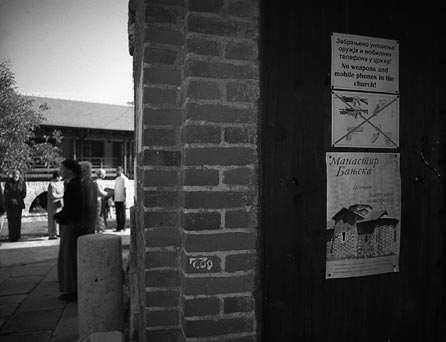 Входные двери церкви в монастыре Баньска. Надпись на плакате гласит: «Запрещено ношение оружия и сотовых телефонов в церковь».